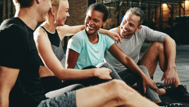 Smiling group of friends talking together after a gym workout